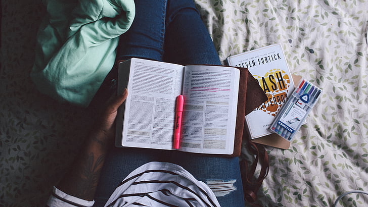 person, reading, studyin, bed, books, marker, pen